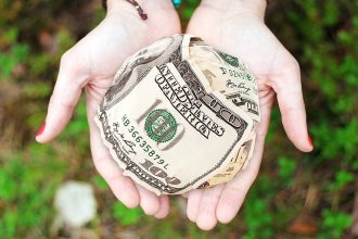 Woman holding emergency funds in the palm of her hand