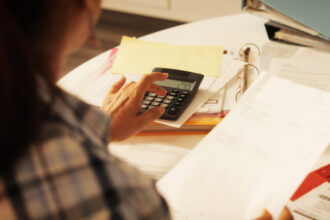 Old people, tax return and home banking. Senior woman paying federal taxes, doing family budget. Elderly person typing on calculator. Concept of money, finance, financial problems