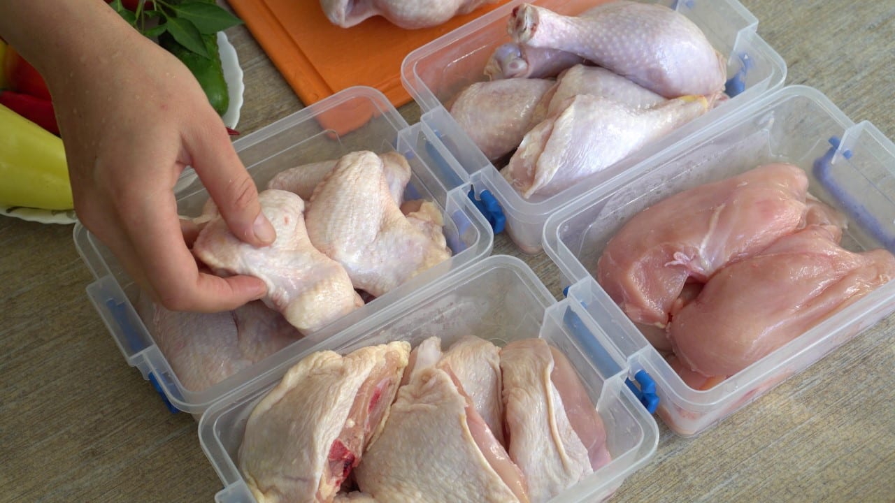Woman portioning out whole chicken in containers