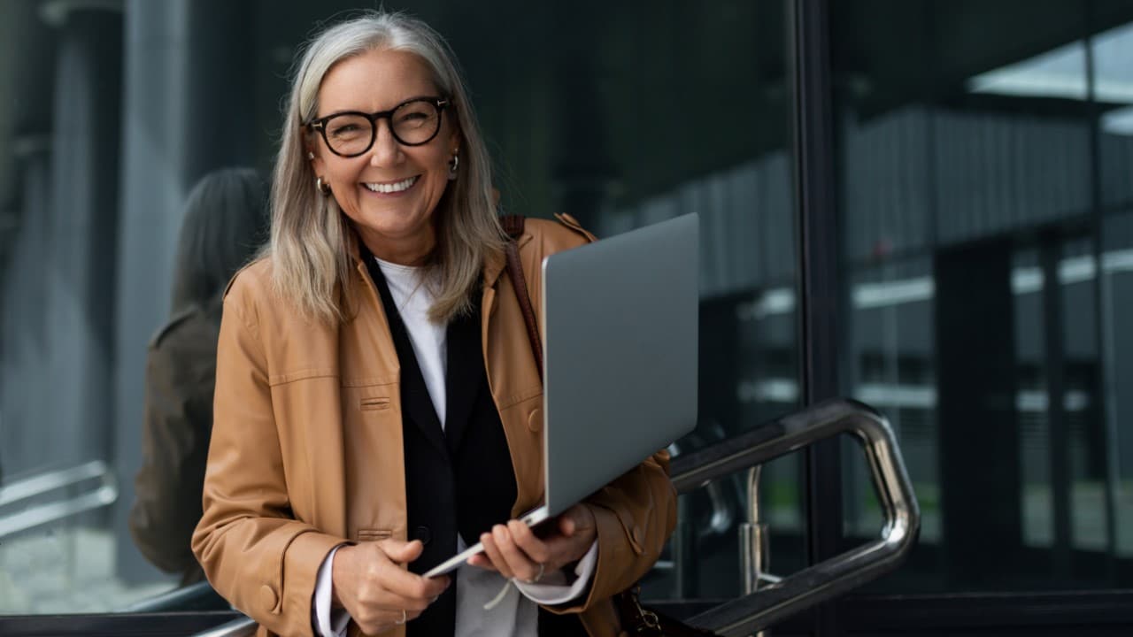 Elderly woman smiling after persisting on her financial goals.