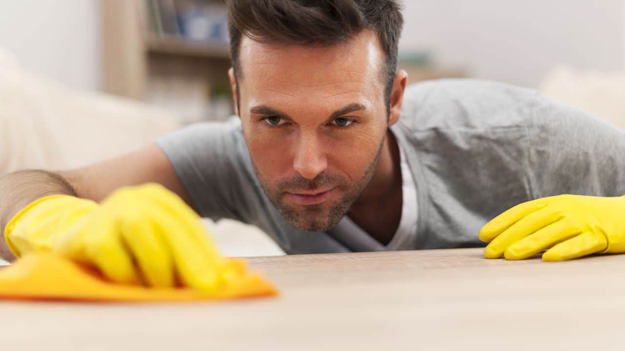 Man cleaning the house with gloves on