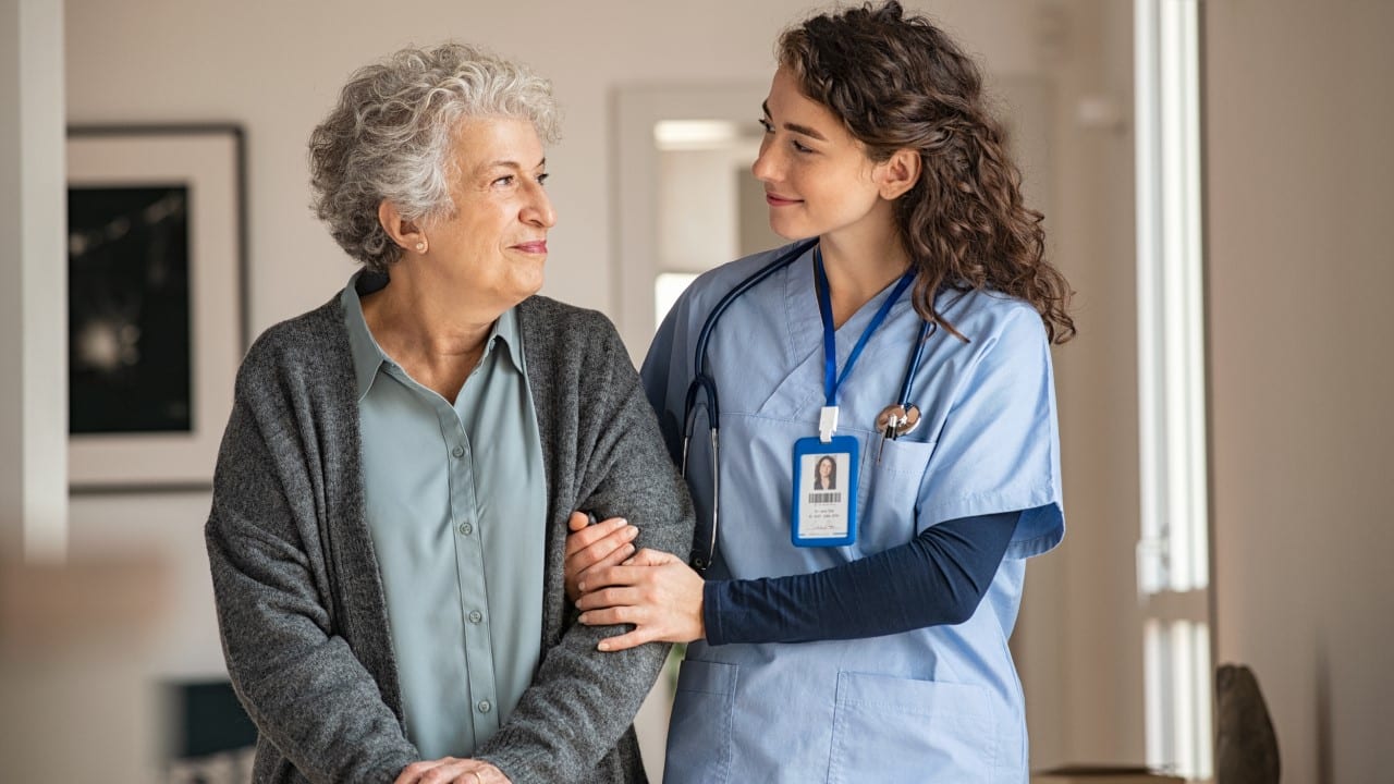 elderly healthcare woman in scrubs helping old lady