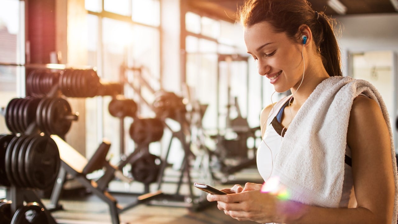 Woman checking phone at gym