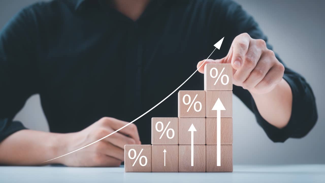 Increasing rates graphic, man pointing to graphic of chart going upward