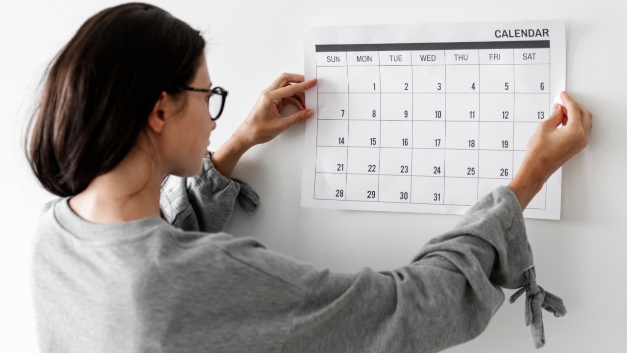 Woman hanging a calendar.