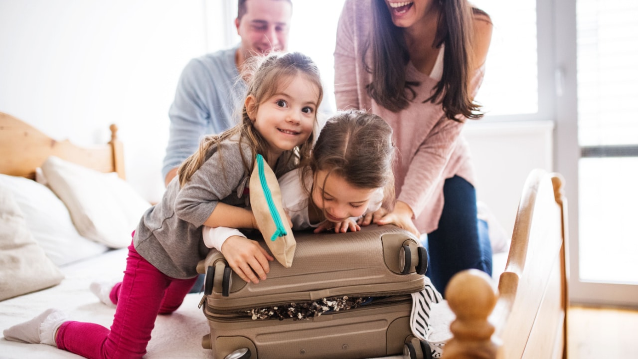 Family squashing full holiday packing suitcase closed