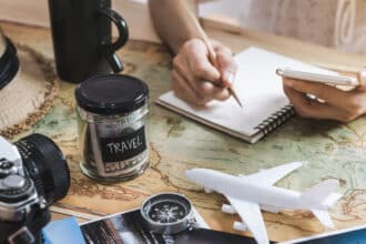 Planning travel on a budget, map, notebook, money jar
