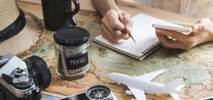 Planning travel on a budget, map, notebook, money jar