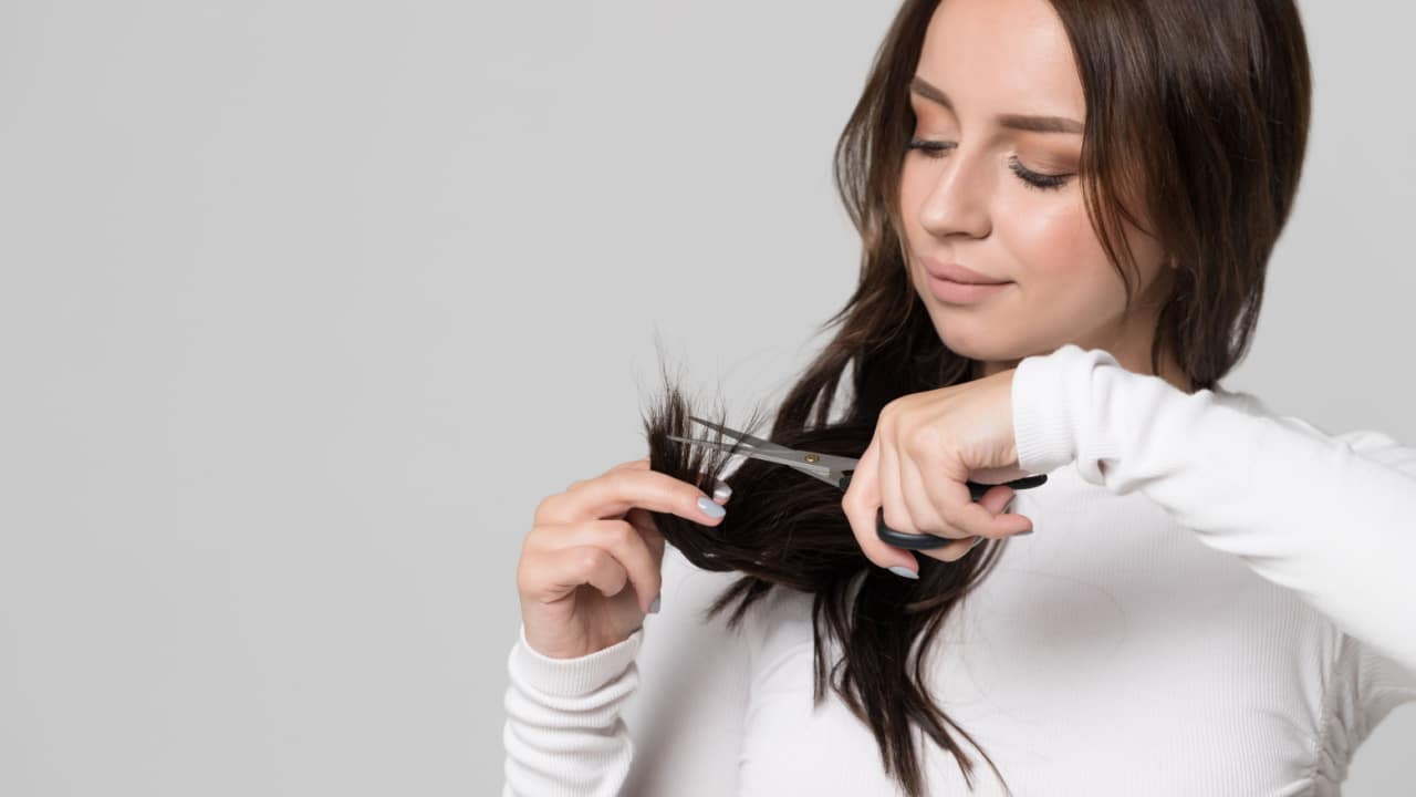 Woman trimming her hair.