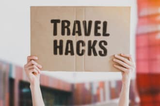 Lady holding travel hacks sign