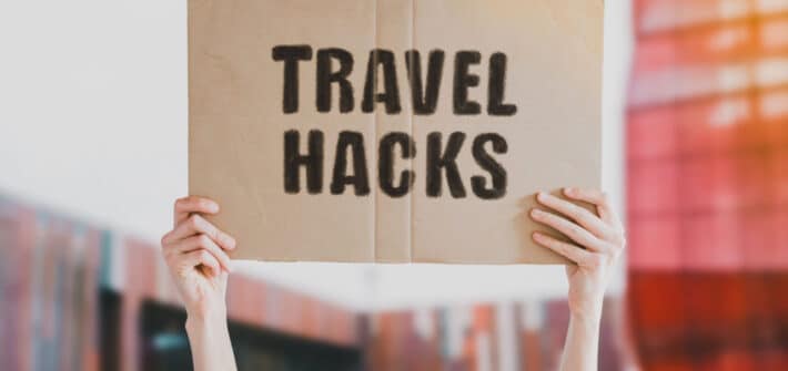 Lady holding travel hacks sign