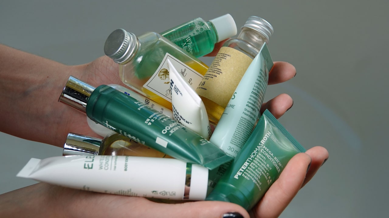 Hands full of travel size toiletries