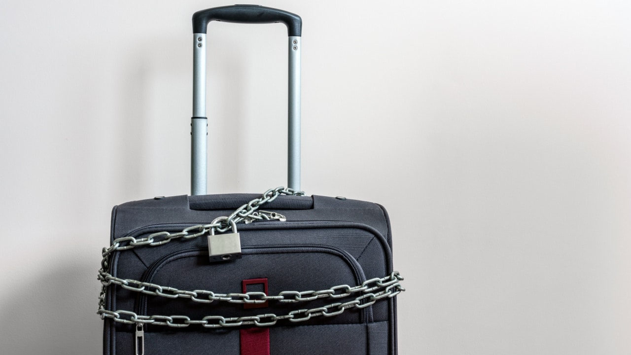 Padlock securing chain around suitcase