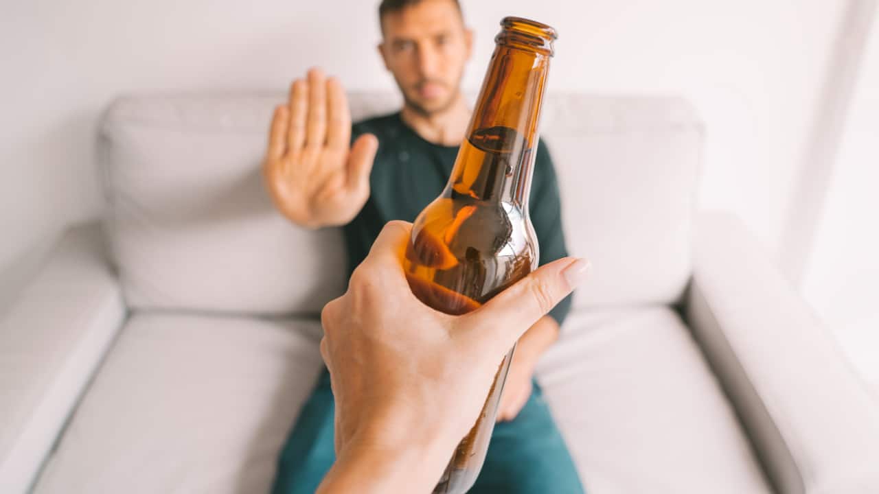 Young man refuses to drink beer. 