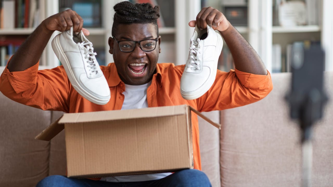 Happy man holding shoes.