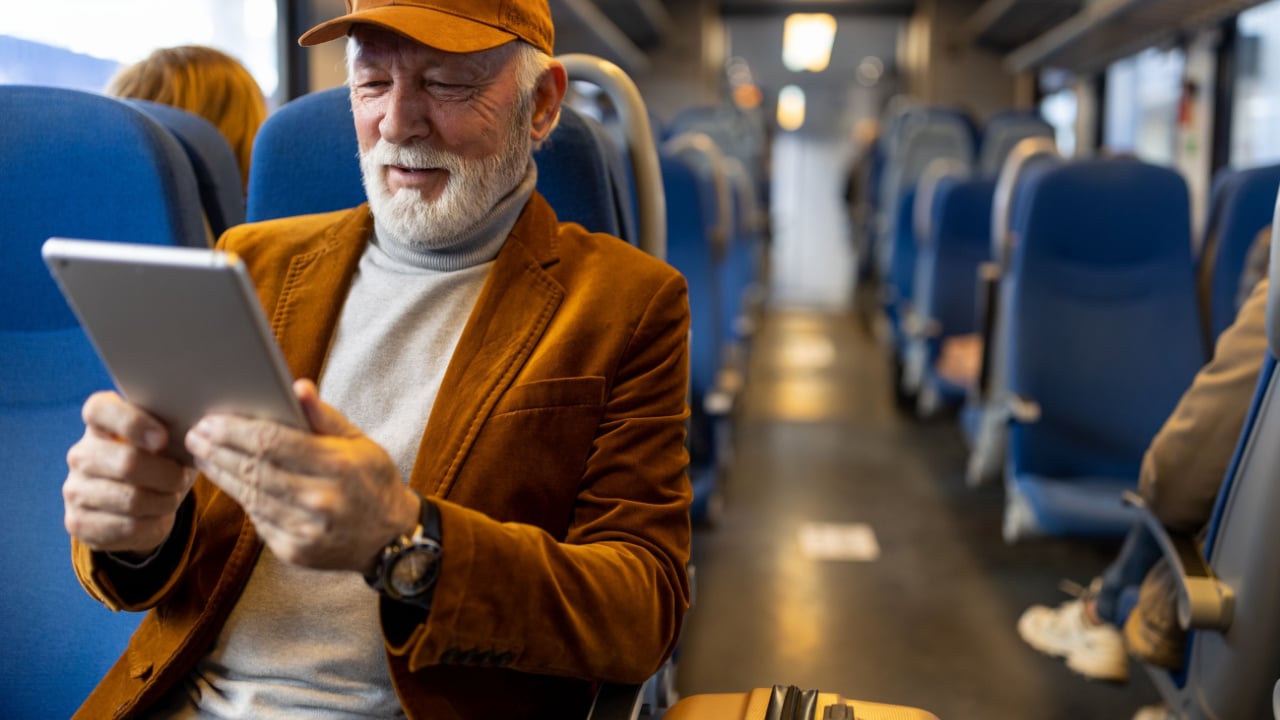 Man reading tablet on train