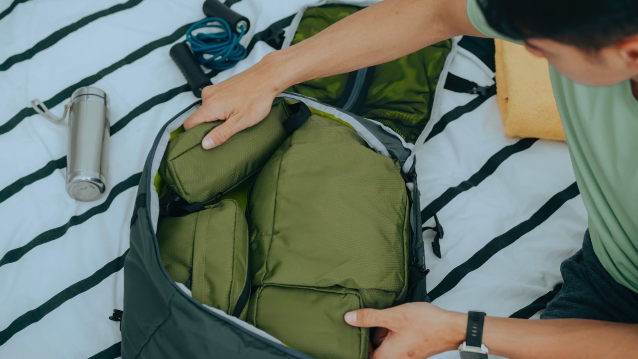 Man putting packing cubes into bag