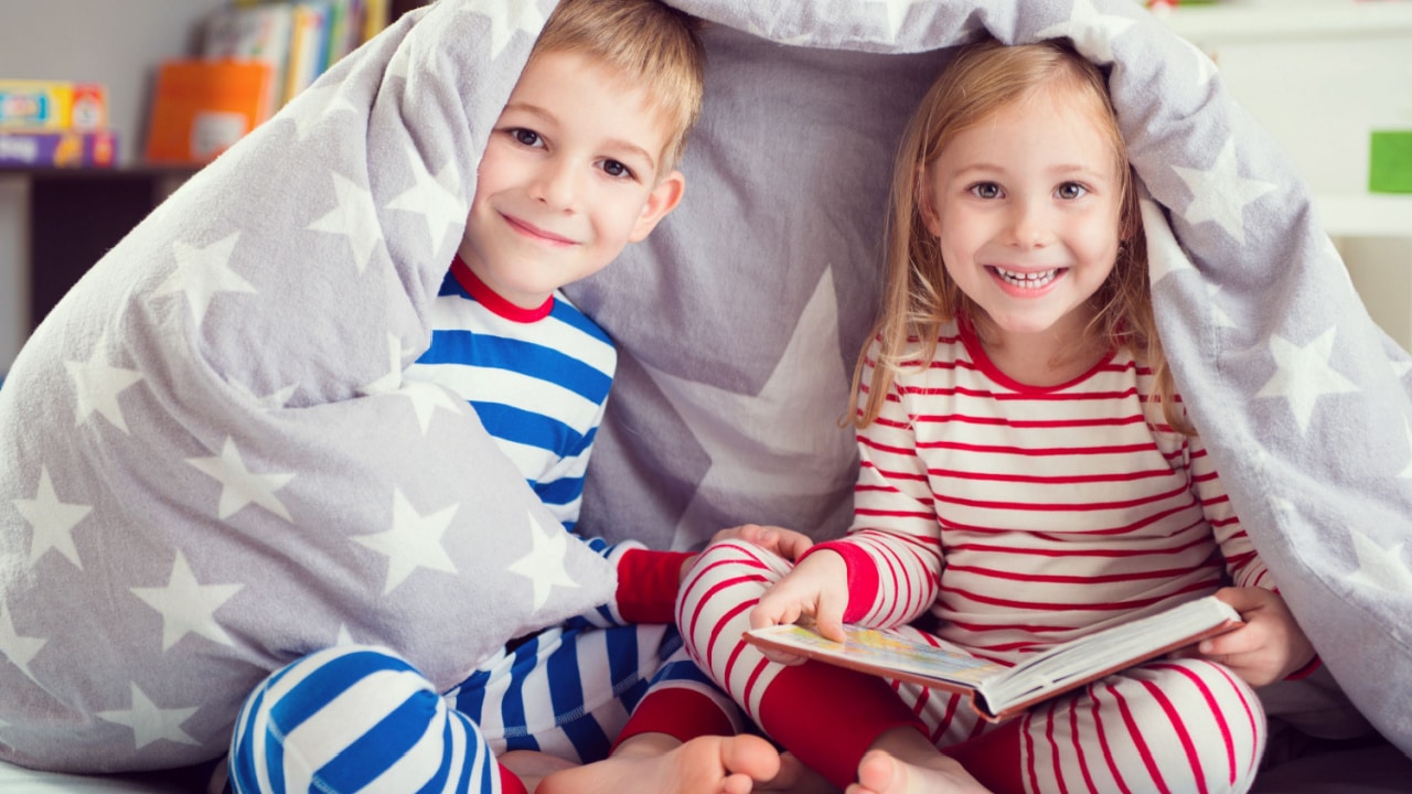 Kids under a blanket fort.