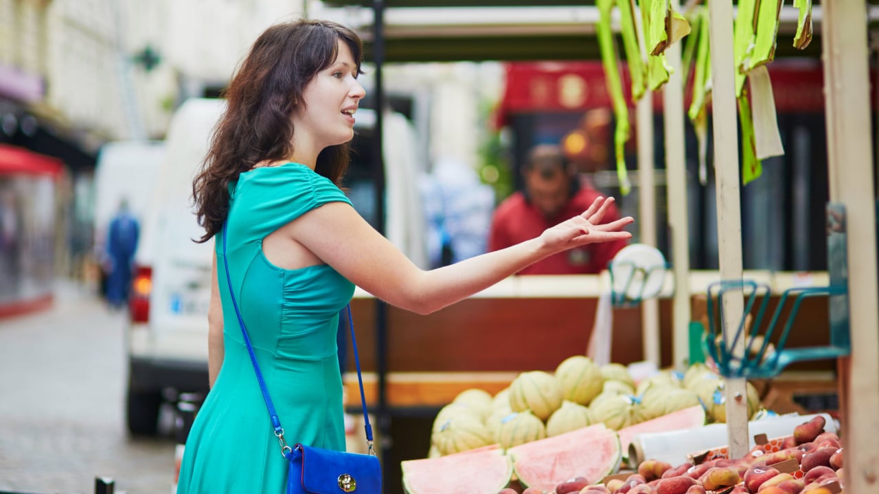 Beautiful woman negotiating the price at a local market.