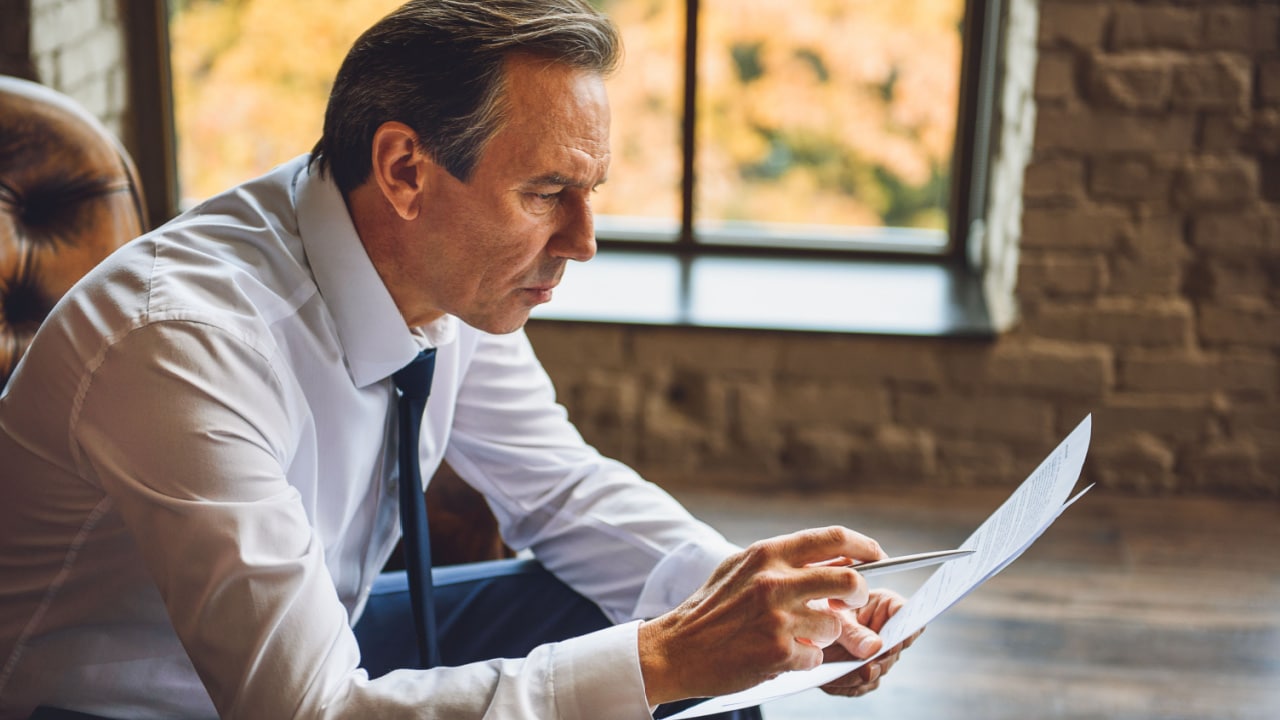 Business man reading fine print.