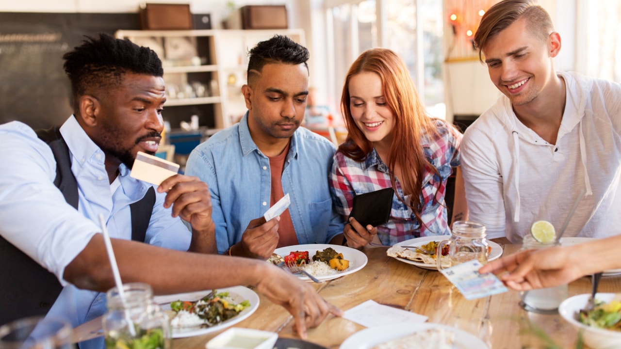 Group eating out, man paying with credit card
