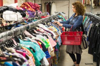 Woman thrifting looking at clothes with red basket
