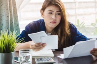 Tired Woman Looking At Bills