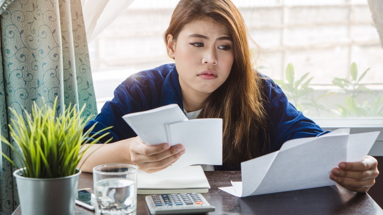 Tired Woman Looking At Bills