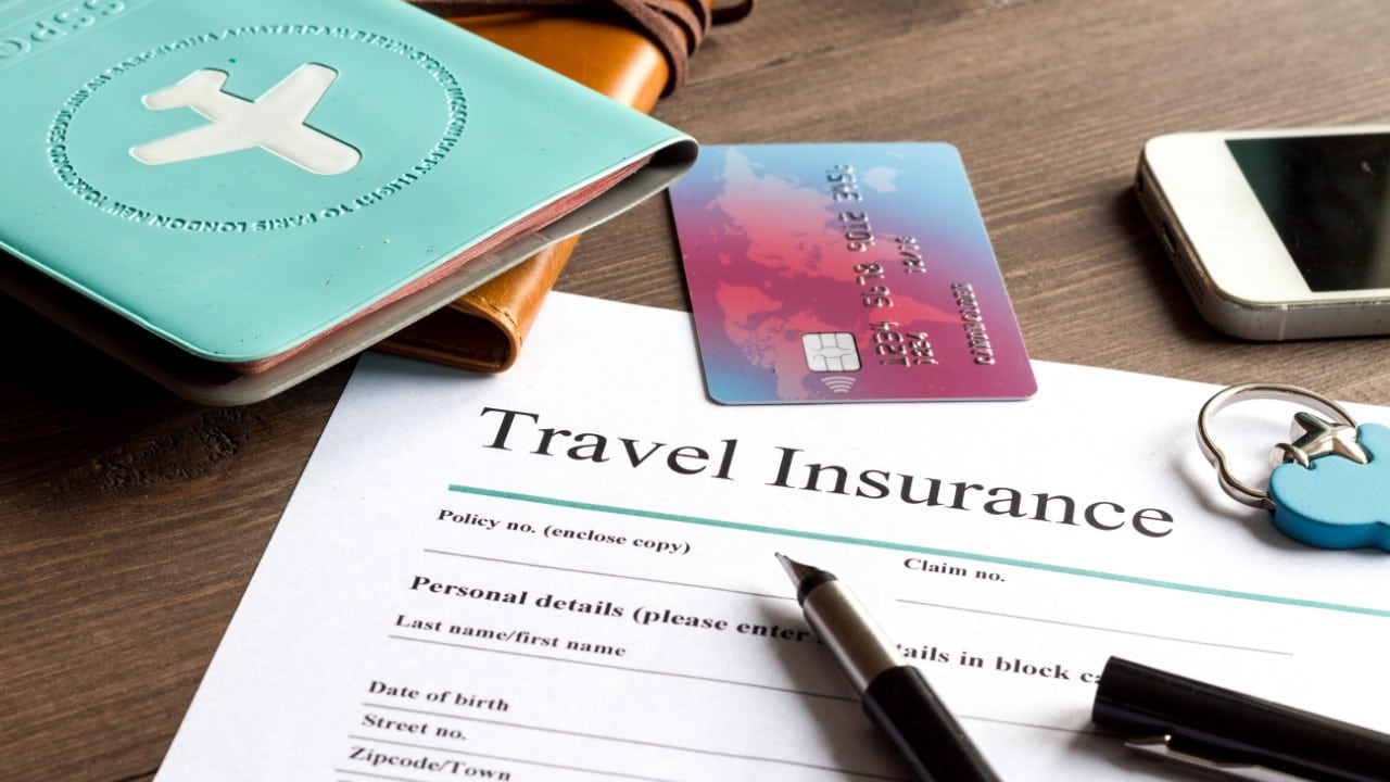 Travel Insurance document laying on desk with other items.