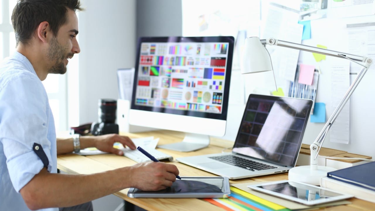 Woman sitting at computer working on graphic design assignment