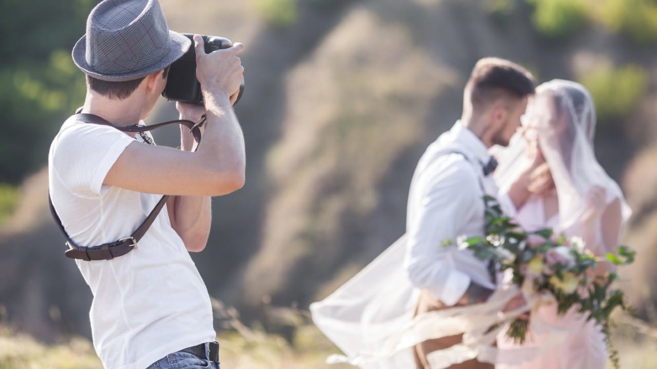 Photographer photographing wedding couple outside