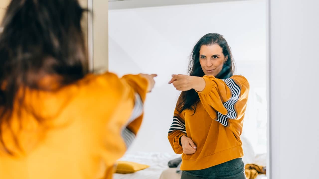 Woman pointing at mirror confident