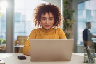 Young woman sitting at computer learning her finances