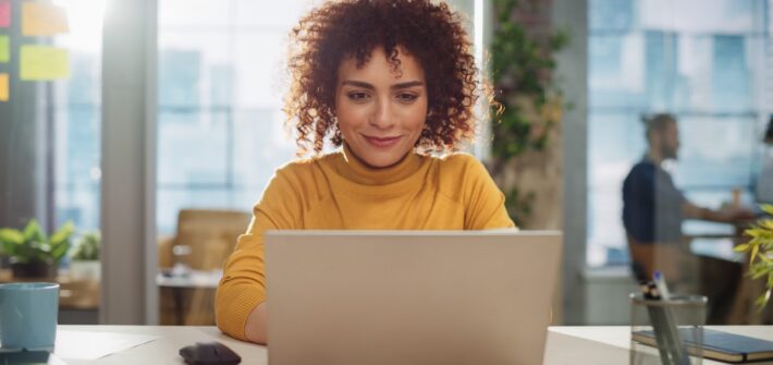 Young woman sitting at computer learning her finances