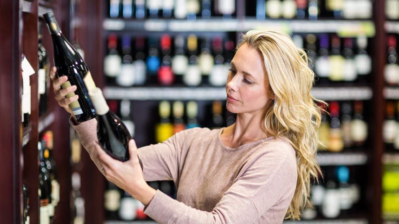 Woman in wine store picking out a wine bottle