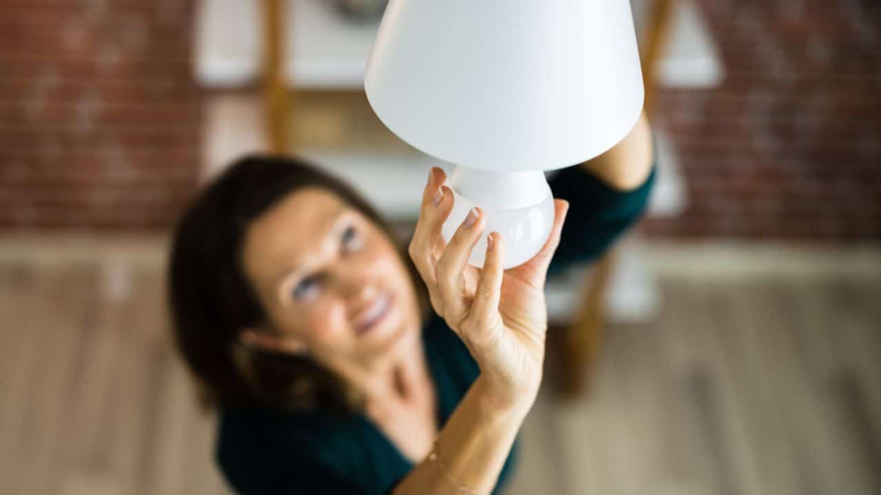 Person screwing in a lightbulb