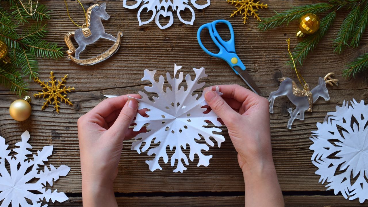 Making paper snowflakes with your own hands. Children's DIY. Merry Christmas and New Year concept.