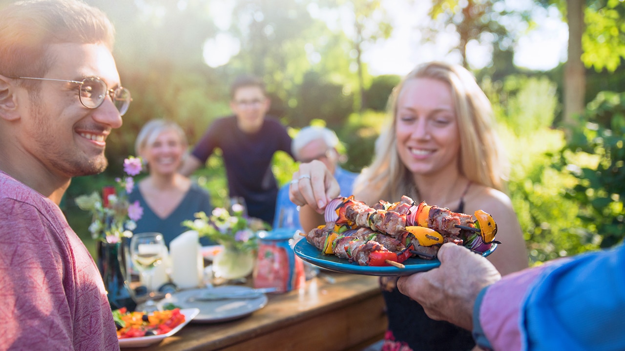 family in the garden at home ready to eat from a barbecue