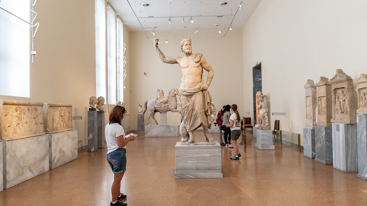 A woman views the famous sculpture, Poseidon of Melos, dated to the second century B.C., at the National Archaeological Museum.