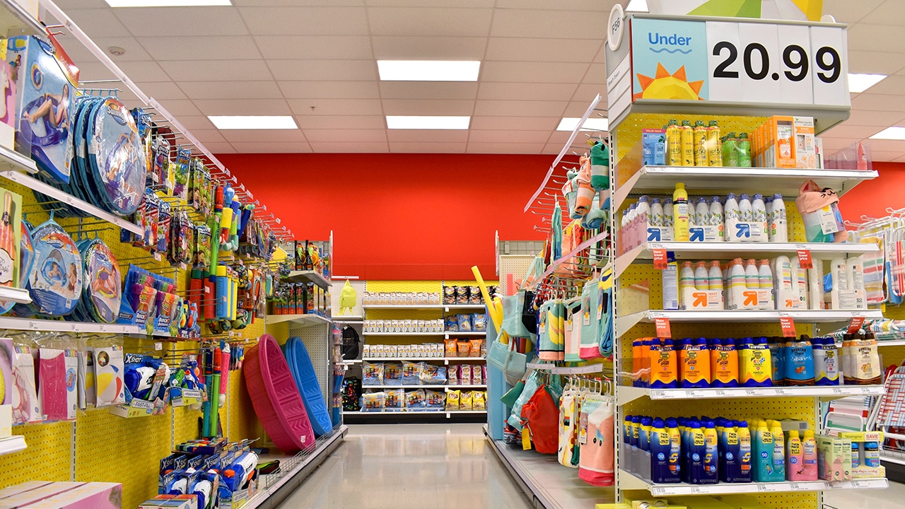 Convenience store aisle with summer toys and supplies, end cap with various brands of sun screens.