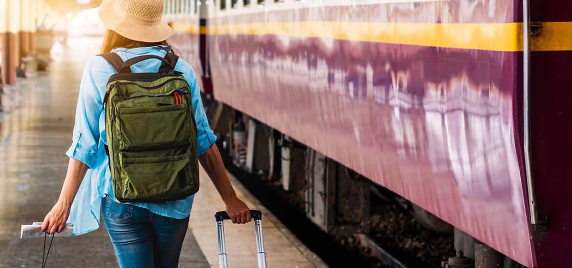 Solo woman backpacker traveler plan safety trip low cost budget summer holiday after coronavirus. Empty tourist on train railway platform. Use bus train sustainable environmental friendly transport