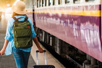 Solo woman backpacker traveler plan safety trip low cost budget summer holiday after coronavirus. Empty tourist on train railway platform. Use bus train sustainable environmental friendly transport