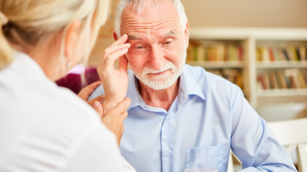 Senior with dementia or Alzheimer's is comforted by caring female doctor