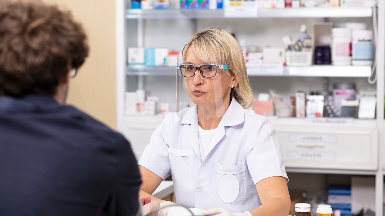 Woman Phamacist wearing facemask take assit to patient in Pharmacy shop