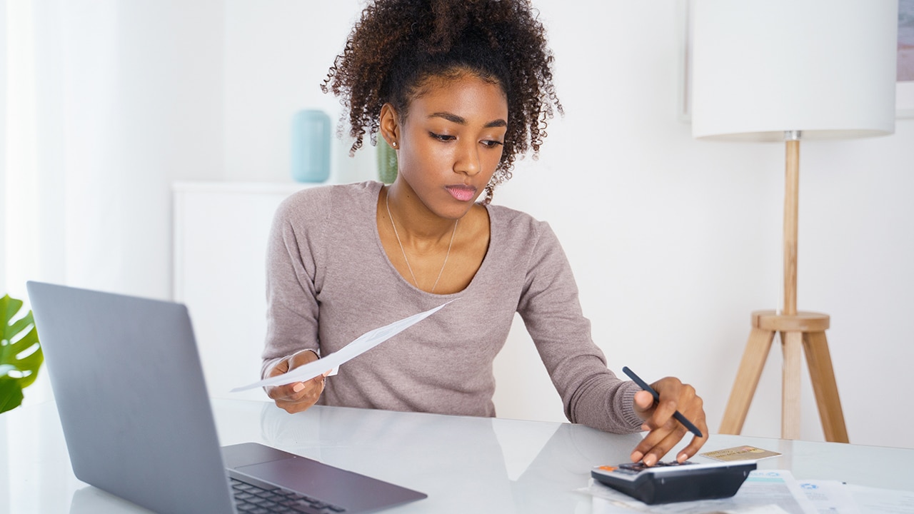 Woman holding paper bill, paying for gas, electricity and rent