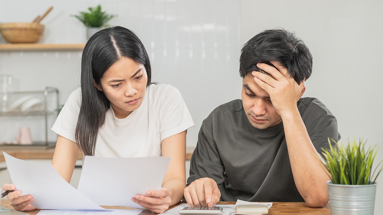 Stressed asian young couple family, wife and husband confused by calculate expense from invoice or bill, have no money to pay. Mortgage, loan causing debt, bankruptcy. Debt problems, Financial people.