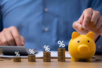 pile of coins and piggy bank, Interest rate and dividend concept Businessman is calculating income and return on investment in percentage. income, return, retirement, compensation fund, investment
