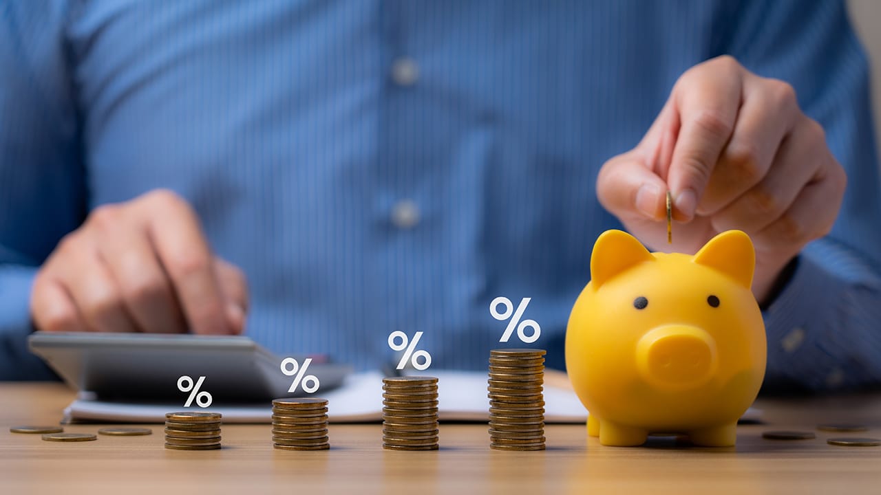 pile of coins and piggy bank, Interest rate and dividend concept Businessman is calculating income and return on investment in percentage. income, return, retirement, compensation fund, investment