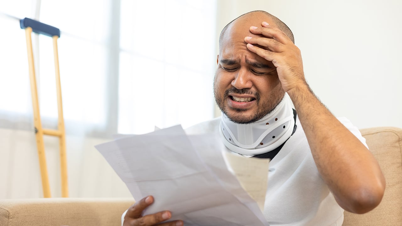 UnHappy man stressed pay invoice medical expenses from accident fracture broken bone injury with leg splints in cast neck splints collar sling support arm. Social security and health insurance.