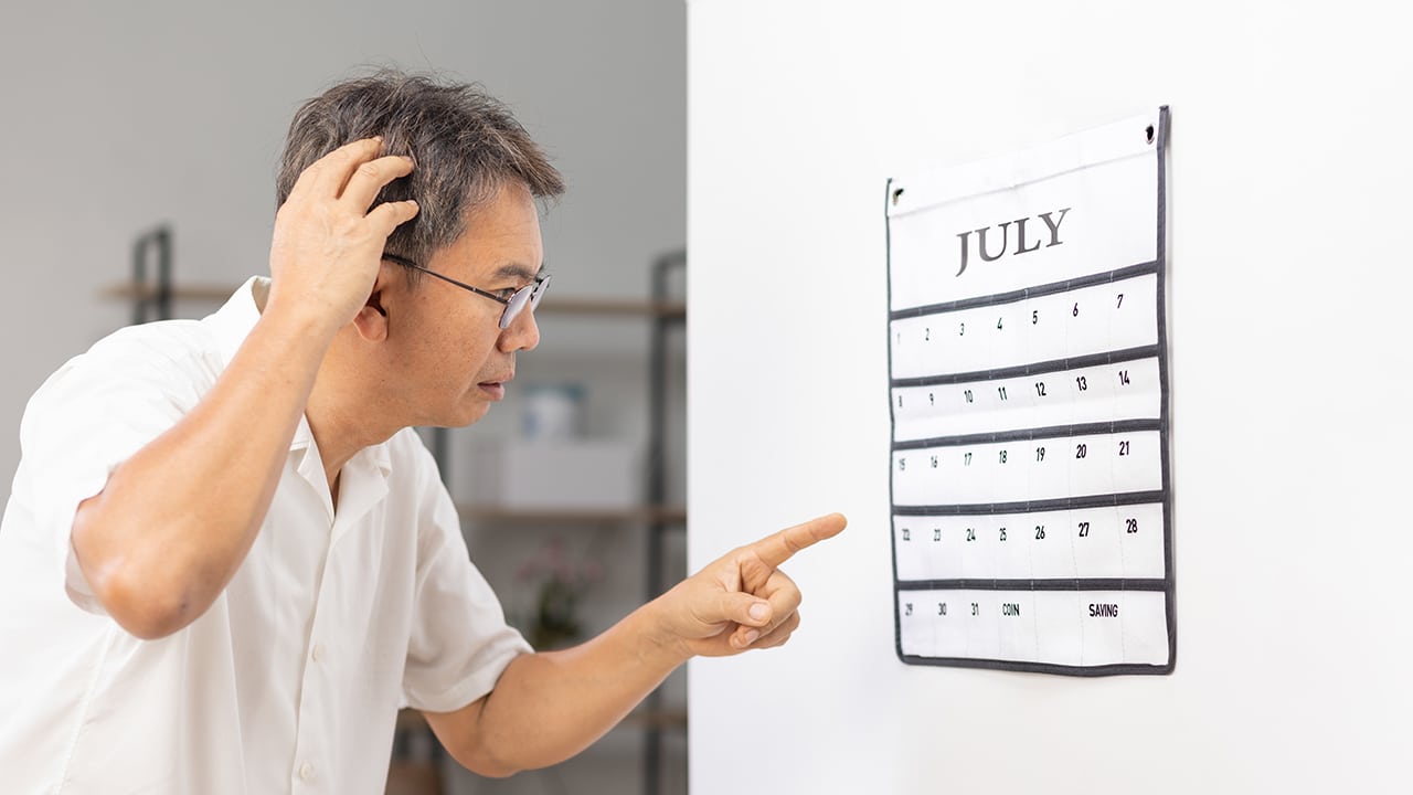 Confused Asian Senior Man With Dementia Looking At Wall Calendar